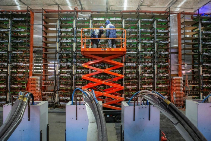 Engineers install mining rigs at a cryptocurrency mining farm in Russia